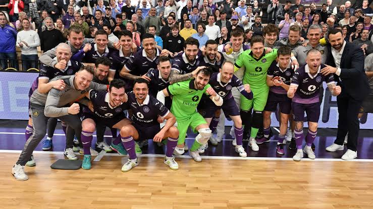 Teamfoto van RSCA Futsal met de supporters op de tribune
